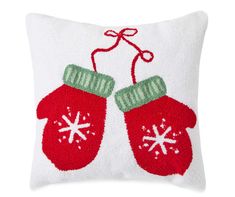 a white pillow with two red mittens on it