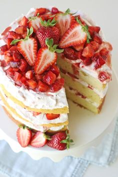 there is a cake with strawberries on the top and one slice cut from it