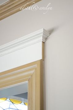 the corner of a room with a stained glass window and white trim on the wall