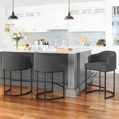 two gray chairs sitting at a kitchen island