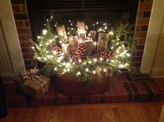 a fireplace decorated for christmas with pine cones and lights