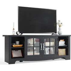 a black entertainment center with glass doors and shelves