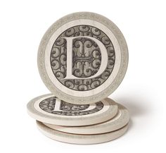 four coasters with the letter d on them in white and grey designs, all stacked together