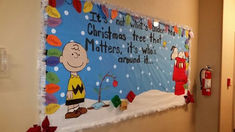 a bulletin board with a charlie brown christmas message on it and decorations around the perimeter