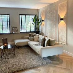 a living room filled with furniture next to two windows and a rug on the floor