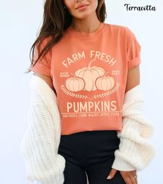 Embrace the autumn season with our Farm Fresh Pumpkins Shirt, featuring a charming design of three pumpkins with the words "Farm Fresh Pumpkins Hayrides, Corn Mazes, Apple Cider." Perfect for trips to the pumpkin patch, this pumpkin crewneck offers the cozy comfort of Comfort Colors. Ideal for any fall outing, this pumpkin patch shirt is a must-have in your collection of autumn tees. Whether you're sipping apple cider or enjoying a hayride, this fall crewneck provides both warmth and style. Add Fall Cotton Shirt In Orange, Orange Cotton Shirt For Fall, Trendy Soft-washed Fall Tops, Trendy Soft-washed Tops For Fall, Cute Fall T-shirt With Relaxed Fit, Cute Pre-shrunk Shirt For Fall, Fall Soft-washed Relaxed Fit Shirt, Soft-washed Cotton Shirt For Fall, Trendy Comfortable Fit T-shirt For Fall