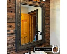 a bathroom mirror sitting on top of a wooden wall