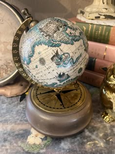 an old world globe sitting on top of a table next to books and other items