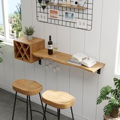 two wooden bar stools next to a shelf with wine bottles and glasses on it