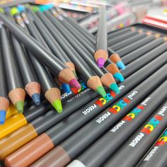 many colored pencils are lined up on the table