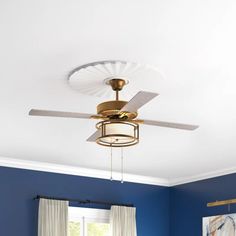 a ceiling fan in a bedroom with blue walls