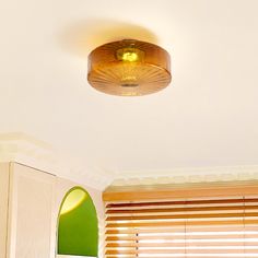 the light is on above the bed in the room that has green walls and white trim