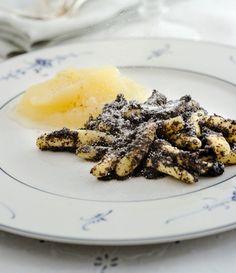 a white plate topped with food next to a pile of powdered sugar on top of it