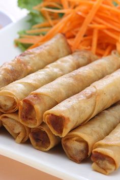 some food is on a white plate with carrots and lettuce next to it