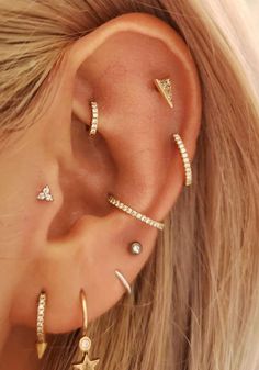 a woman wearing three different ear piercings