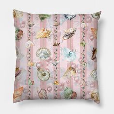 a pink pillow with seashells and pearls on it