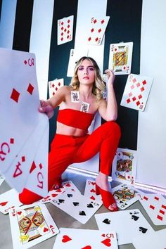 a woman sitting on the floor surrounded by playing cards