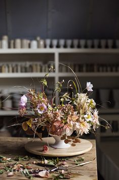 a vase filled with flowers sitting on top of a wooden table next to other items