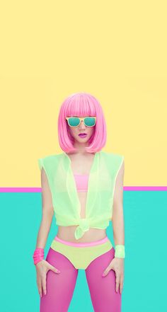 a woman with pink hair and sunglasses standing in front of a colorful wall wearing neon colored clothing