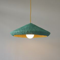 a green and yellow lamp hanging from a ceiling