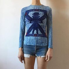 Brand New, Never Worn, No Tags. Jean Paul Gaultier Egyptian Hieroglyphs Long Sleeve 90s Top. Very Stretchy Sheer Tattoo Style Shirt. Long Sleeve. Eye Of Horus, Egyptian Scarab Beetle, Hieroglyphics Across Background. Color Is Almost A Blue Tie Dye Effect With Vibrant Red Details. Gaultier Jeans Logo Graphic Across Front, Gaultier Jeans Label On Back. Orange Contrast Stitching. Bella Hadid Second-Skin Style. Very 1990s, 90s Y2k Style. Size 42, Fits Xs-M Depending On Desired Fit. Box Pc. Designer Printed Blue Tops, Designer Blue Printed Tops, Designer Fitted Top With Graphic Print, Designer Fitted Printed Tops, Blue Reworked Long Sleeve Top, Blue Long Sleeve Reworked Tops, Egyptian Scarab Beetle, Jeans Label, 90s Jean