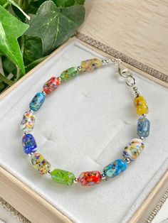 "Stunning Murano Glass beaded bracelet with old world charm! These vintage beads from an old stock from the Mazzucco Co. of Murano, Italy are from the 1950's. Each glass bead is unique with opaque colors of blues, green, red, yellow and white and speckles of all colors on each. The beads are small barrel shapes at 10mm. Sterling silver lobster claw clasp. The bracelet measures 7.5inches. ( Please measure your wrist carefully for the best fit ) These beads are artisan made and timeless. For those Vintage Spacer Beads Bracelets Gift, Spiritual Czech Glass Bracelets With Large Beads, Multicolor Polished Oval Bead Bracelets, Multicolor Polished Oval Beads Bracelets, Multicolor Oval Beads Bracelets With Polished Beads, Spiritual Glass Bracelets With Colorful Beads, Spiritual Hand-strung Glass Bracelets, Vintage Glass Beaded Bracelets, Vintage Glass Beaded Bracelets With Colorful Beads