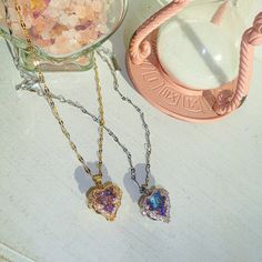 A whimsical and dainty piece that looks as if it was plucked from the pages of a fairy tale. The Fae Heart Necklace features a mesmerizing stone that beautifully shifts colors in the play of light. Wear it and let your heart shine with every enchanting hue, a true symbol of magic and wonder. For the days when your heart seems trapped in a cage, and simply getting out of bed feels like a heavy wage.... I hope you look for the light within you trying to burst through, because, like fairies, we carry diamonds in our hearts too. lab created diamond with magenta and teal hues incased in cubic zirconia studded gold/silver molding chain measures 16 inches + 2 inch extender clasp gold/silver plated stainless steel, non-tarnish and waterproof chain Gift Crystal Necklaces With Clavicle Chain And Heart Pendant, Whimsical Silver Jewelry With Heart Beads, Magical Iridescent Jewelry For Gifts, Whimsical Gold Heart Necklace, Iridescent Heart Pendant Jewelry For Valentine's Day, Multicolor Fairycore Jewelry For Gifts, Fairycore Multicolor Jewelry For Gifts, Magical Gemstone Necklaces As Gift, Magical Gemstone Necklaces For Gifts