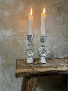 two candles sitting on top of a wooden table