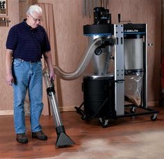 a man standing next to a vacuum cleaner