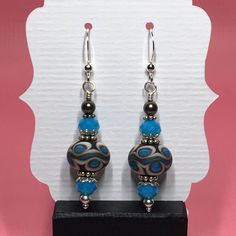 These earrings are made with turquoise and brown lampwork beads, turquoise Chinese crystals, small brown Swarovski pearls, sterling silver bead caps, sterling silver spacer beads and small round sterling silver beads dangling from sterling silver earwires. The earrings measure 2 inches from the top of the earwires. Click here to see other earrings in my shop: https://www.etsy.com/shop/JewelryDesignsByRita?section_id=14765680 I have been designing and making jewelry since 2010. I use only the hig Unique Sterling Silver Beaded Earrings, Turquoise Czech Glass Beaded Earrings, Artisan Turquoise Beaded Earrings With Ear Wire, Artisan Czech Glass Beaded Earrings Nickel Free, Nickel-free Turquoise Czech Glass Jewelry, Turquoise Nickel-free Czech Glass Jewelry, Turquoise Sterling Silver Earrings With Silver Beads, Turquoise Czech Glass Round Bead Earrings, Turquoise Czech Glass Jewelry With Spacer Beads