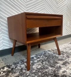 a small wooden table sitting on top of a carpeted floor next to a wall