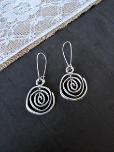 Bohemian Silver Spiral Earrings    These earrings are versatile and comfortable to wear. They will go with almost any outfit. They are great for gift giving or as a treat for yourself. 🌻 Measurements: The focal spiral charm is approximately 1 inch in diameter. The earring drop size/diameter is approximately 1.10 inch. (if choosing bean hooks, please see below.) The earring's total size (with the hooks included) is around 1.50 inch. With bean hooks: all the sizes will increase by 1 inch.  These earrings will be approximately 2 inches in total length with bean hooks. ⭐Colors may slightly vary due to the differences in screen monitor settings vs. real life lightings. Shipping:   I ship within 2 business (non-holiday) days of the purchase. The shipping service I use is First Class Package off Unique Spiral Ear Wire Earrings, Swirl Earrings For Pierced Ears, Swirl-shaped Earrings With Ear Wire, Metal Spiral Earrings With Ear Wire, Spiral Metal Earrings With Ear Wire, Swirl Shaped Metal Earrings For Gift, Swirl Shaped Metal Earrings As Gift, Swirl-shaped Pierced Earrings For Gift, Handmade Metal Swirl Earrings