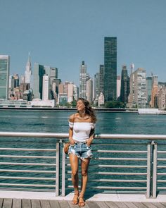 a woman standing on a pier next to the water