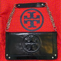 Authentic Beautiful Tory Burch Bombe Reva Clutch. Black Leather With A Patent Leather Border And Silver Color Hardware. Detachable Chain Strap Makes It Into A Handheld Clutch. Magnetic Closure. Two Interior Zip Pockets. Tory Burch Dustbag Included. Scratches Are Present. Designer Black Clutch Shoulder Bag, Designer Black Shoulder Bag Clutch, Designer Black Shoulder Clutch, Clutch Black, Tory Burch Bag, Magnetic Closure, Chain Strap, Silver Color, Patent Leather