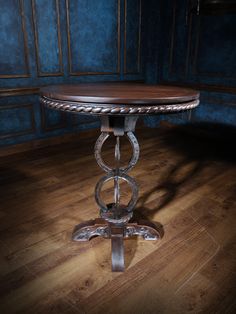 a wooden table sitting on top of a hard wood floor next to a blue wall