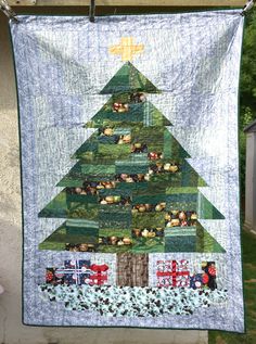 a quilted christmas tree hanging on a clothes line with an image of people around it