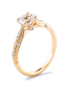 a yellow gold engagement ring with an oval center stone and side stones on the sides