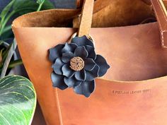 a leather bag with a flower attached to it