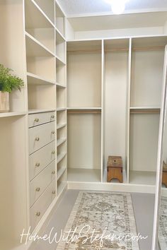 a walk in closet with white shelving and drawers, carpeted flooring and plants