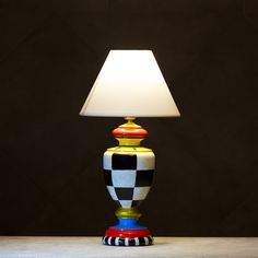 a lamp that is sitting on a table with a black and white checkerboard pattern