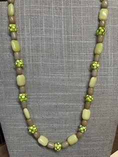 This necklace has 32 pale green rondelles, with five square marbleized, flat beads at the center.  It has a brass lobster claw clasp. Green Beaded Rectangular Necklace, Green Rectangular Beaded Necklace, Vintage Green Rectangular Necklace, Single Strand Green Czech Glass Beads, Flat Beads, Green Beaded Necklace, Pale Green, Lobster Claw, Pendant Necklaces