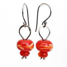 "These red earrings feature four colorful poppy red beads that I handmade in my studio.  The lampwork beads have been stacked and wire wrapped using sterling silver wire.  Bright, colorful, and beautiful! Handmade Red Lampwork Glass Beads 1.5\" L x .5\" W 925 Sterling Silver Findings and Ear Wires Comes in a signature kraft jewelry box ready for gifting ~ About Me: My name is Kathy Bankston, and I am a metalsmith and lampwork bead maker. All my items are completely handmade by me from start to finish. I do everything, from designing and sketching, to sawing every little piece out with a hand saw, filing and shaping, and soldering it all together. My glass beads are made from Effetre soda glass and are kiln annealed in my studio. Many of my items are one of a kind, only a few are designs th Red Beaded Earrings, Red Bead Earrings, Lampwork Bead Earrings, Lampwork Earring, Earrings Colorful, Red Beads, Poppy Red, Jewelry Beaded, Jewelry Studio