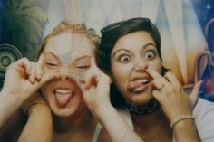 two women are posing for the camera with their hands on their faces