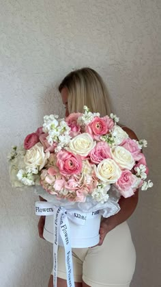 a woman holding a large bouquet of flowers