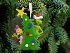 a christmas ornament hanging from a tree with an elf and snowman on it