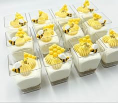 small desserts are arranged in glass dishes on a white tablecloth with honeycombs and bees