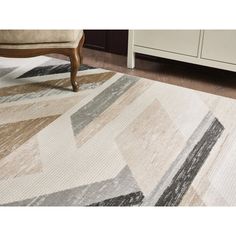 a beige and black area rug on the floor with a chair in front of it