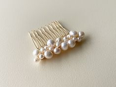 "P1002 CLUSTER PEARL HAIR COMB (SMALL) An elegant and timeless pearl gold wedding hair piece. This hair comb features an assortment of freshwater ivory pearl clusters carefully hand wired onto a gold hair comb. Suitable for weddings, proms, or any other special occasions. If you are looking for a simple yet classy look, this one is for you!  PRODUCT DETAILS Composed of freshwater pearls (varying sizes), gold coloured wire, gold hair comb Dimensions are approximately 2\" (5 cm) (W) x 1.75\" (4cm) Gold Wedding Hair Piece, Silver Wedding Hair, Pearl Wedding Hair, Pearl Hair Piece, Pearl Comb, Pearl Hair Comb, Silver Hair Comb, Gold Hair Comb, Pearl Hair Combs