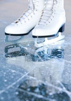 a pair of white ice skates sitting on top of an ice flaker