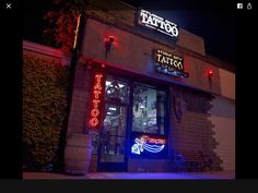 a taco restaurant with neon lights on the front and side of it at night